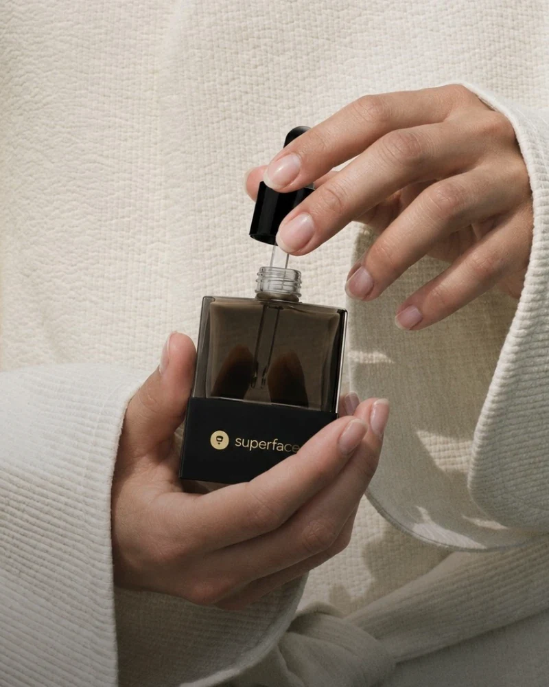 Hands opening a bottle of Superface serum